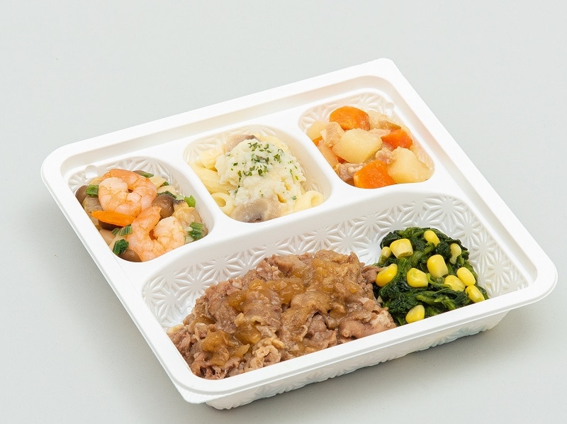 食宅便の牛肉の洋風ソースと副菜が白い仕切り容器に入った献立例